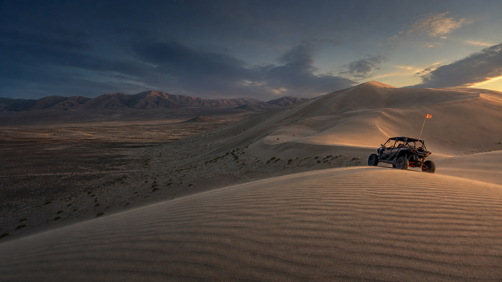 Side-by-side overlooking the rolling Sand Mountain dunes at sunset